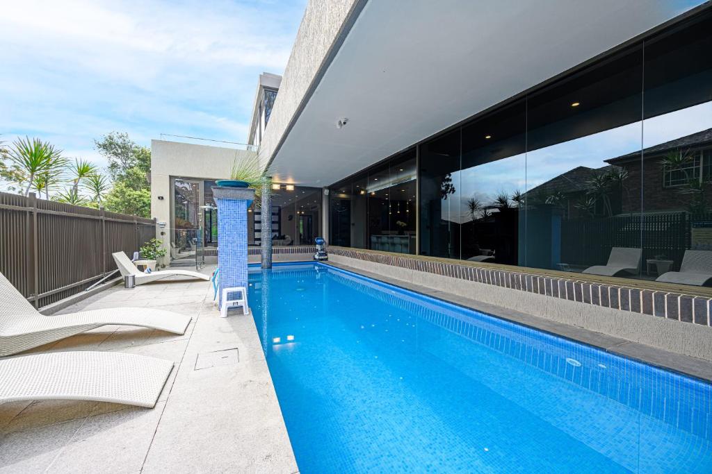 a swimming pool in front of a house at Putney Brand New Luxury House Pool & Waterview in Sydney