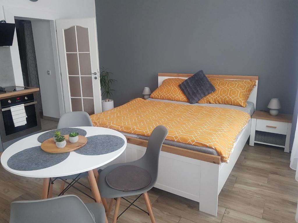 una piccola camera con letto, tavolo e sedie di Apartmán Uršula a Jáchymov