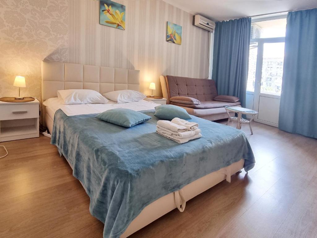 um quarto com uma cama grande e um cobertor azul em Home-Hotel Apartments on Maidan Nezalezhnosti Square em Kiev