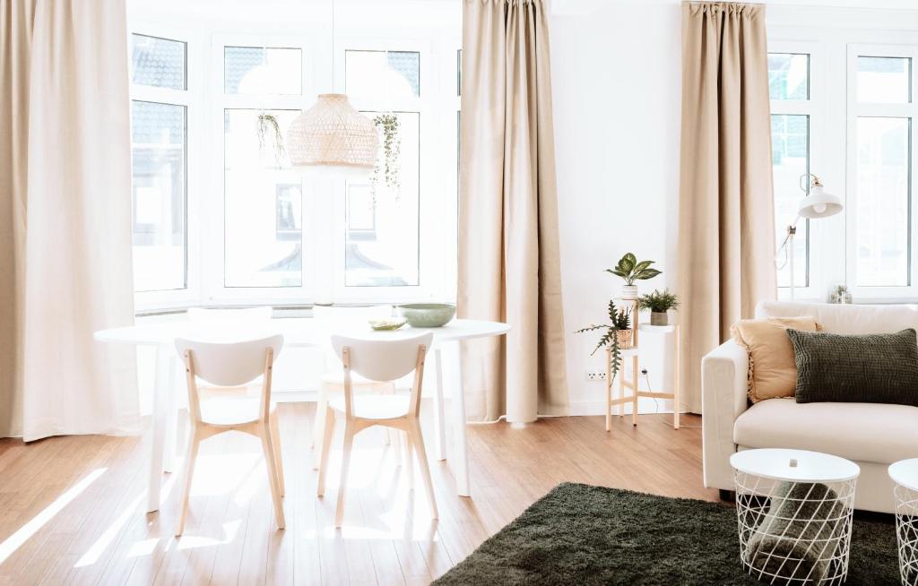 uma sala de estar com uma mesa branca e cadeiras em Deichstadt Apartments em Neuwied
