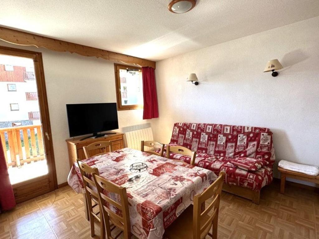 un soggiorno con tavolo e divano di Appartement Puy-Saint-Vincent, 3 pièces, 6 personnes - FR-1-504-599 a Puy-Saint-Vincent