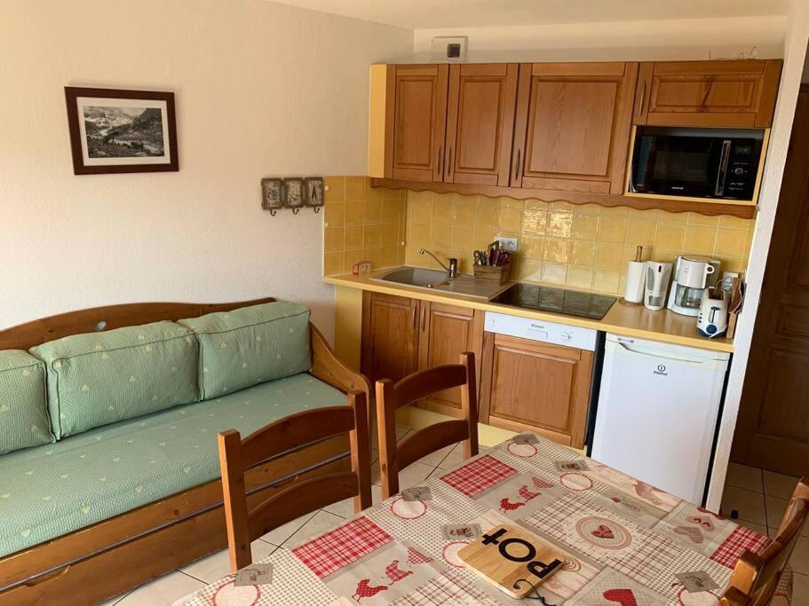 una cocina con un sofá y una mesa y una cocina con una mesa en Paradiski proche des pistes plan peisey, en Peisey-Nancroix