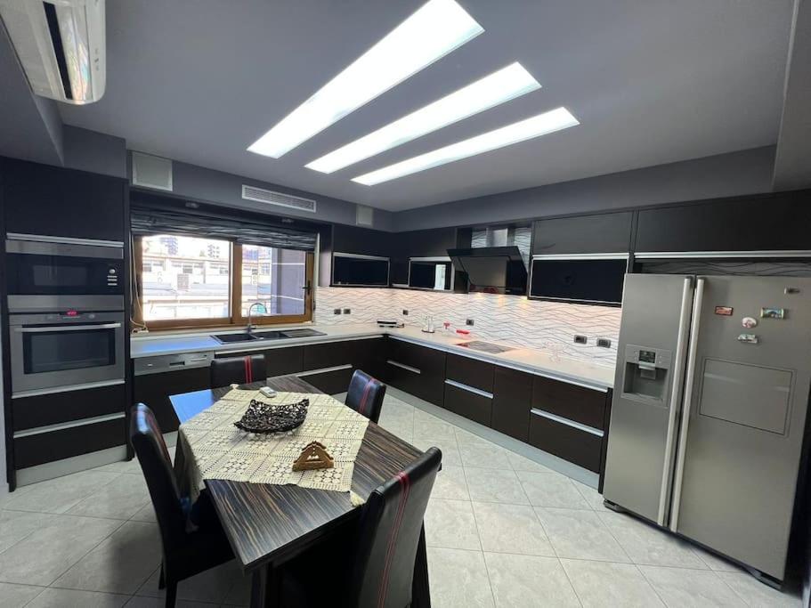 Il comprend une cuisine équipée d'une table et d'un réfrigérateur. dans l'établissement Manga Apartments 3+1, à Gjirokastër
