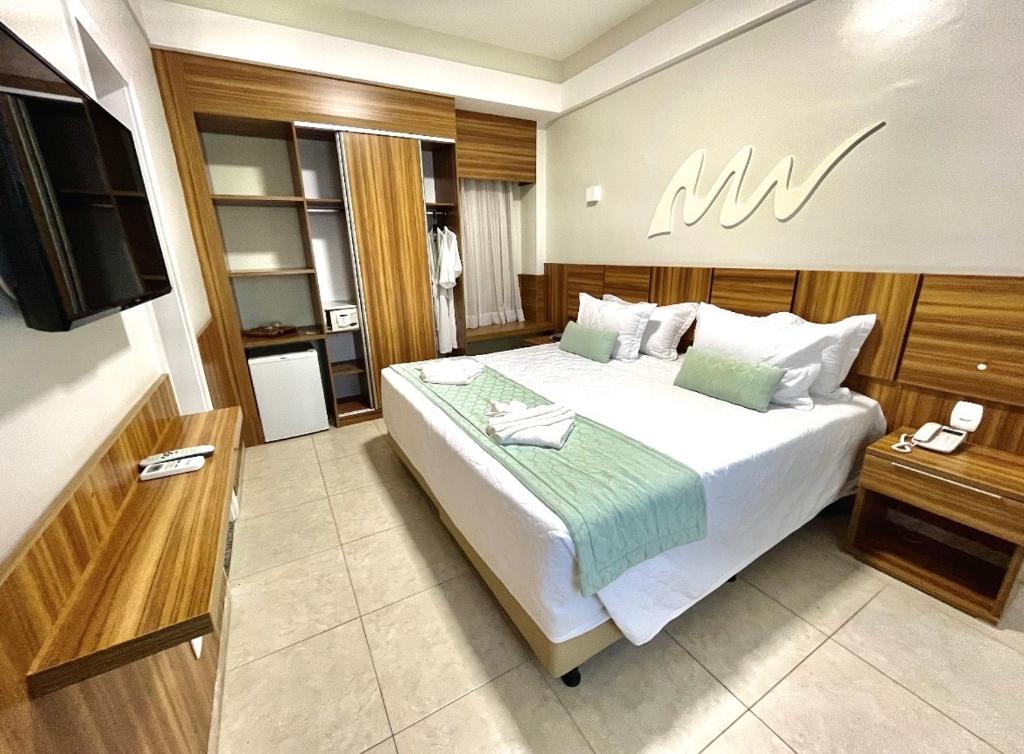 um quarto com uma cama grande e uma televisão em Real Classic Hotel em Aracaju