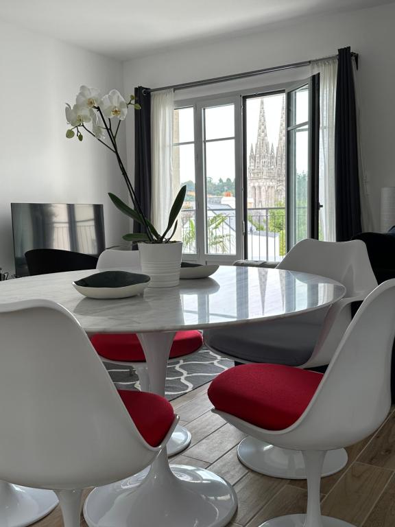 una sala da pranzo con tavolo e sedie bianchi di Appartement Design X - Hyper Centre - Parking Privé - Quimper a Quimper