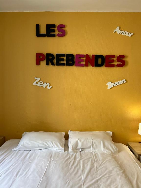 un panneau sur un mur au-dessus d'un lit avec des draps blancs dans l'établissement F2 face au Jardin des prébendes de Tours, à Tours