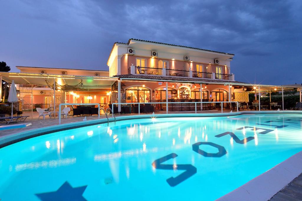 a large swimming pool in front of a building at Maltezos Hotel in Gouvia