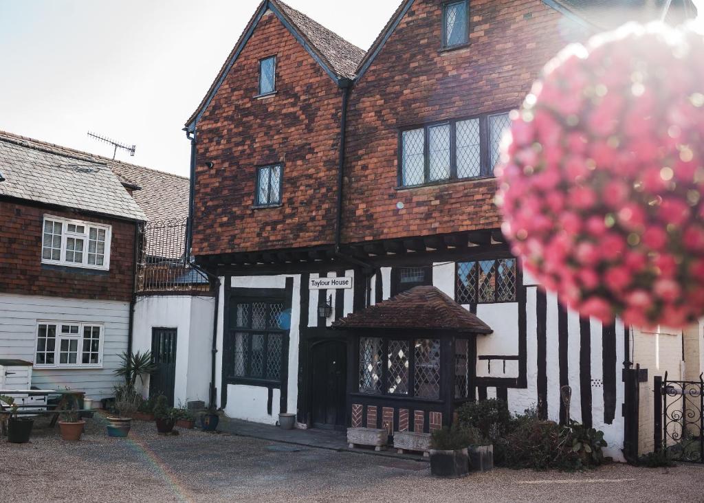una casa vieja con una bola roja delante de ella en Taylour House - Edenbridge, en Kent