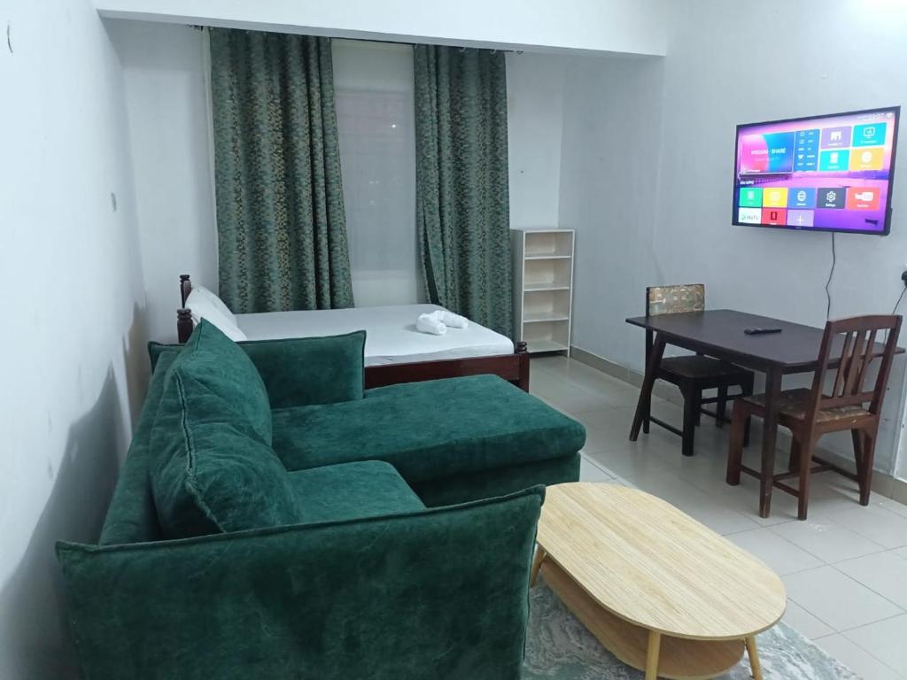 a living room with a green couch and a table at Studio Apartment.Mombasa, Kenya in Mombasa