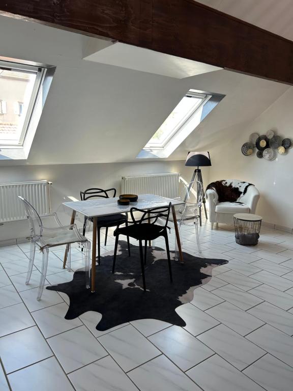 Spacieux duplex à Folschviller : غرفة معيشة مع طاولة وكراسي ومنازل