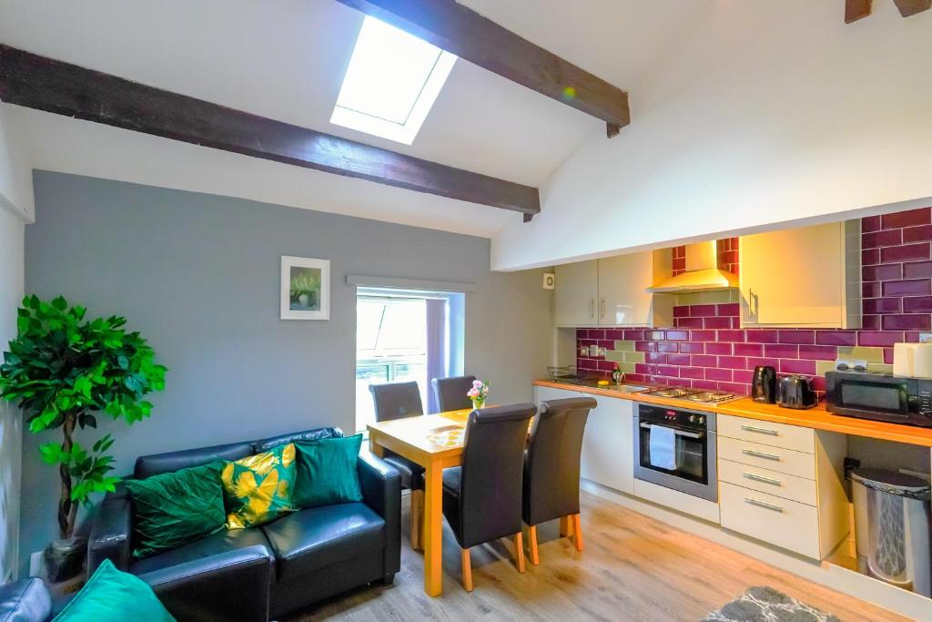 a living room with a table and a kitchen at Headingley 2 Bedroom cottage flat Near Universities shops& Park in Leeds