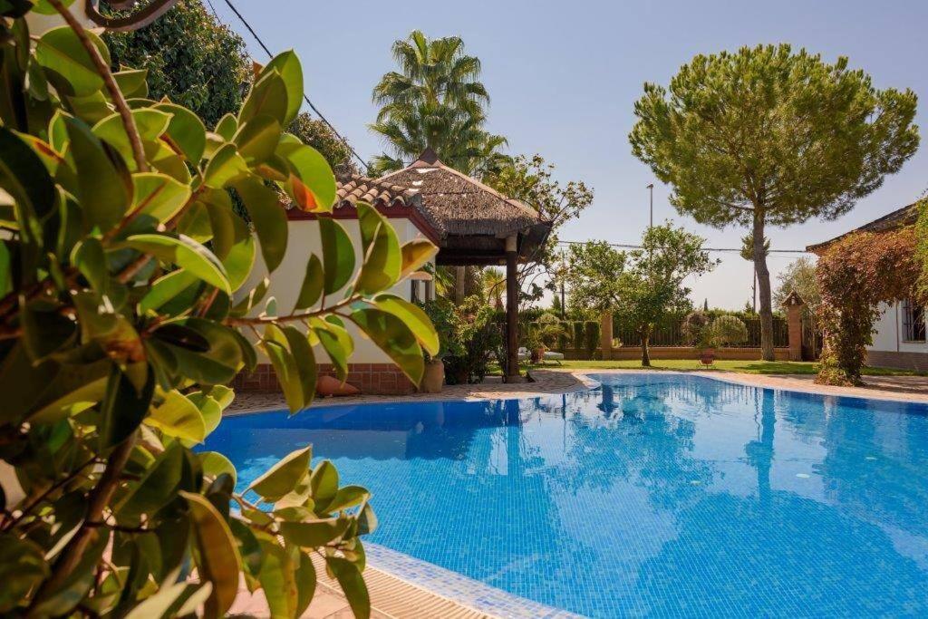 Una gran piscina azul con un cenador en Andalusian Villa w/ Pool, Garden & Barbecue, en Écija