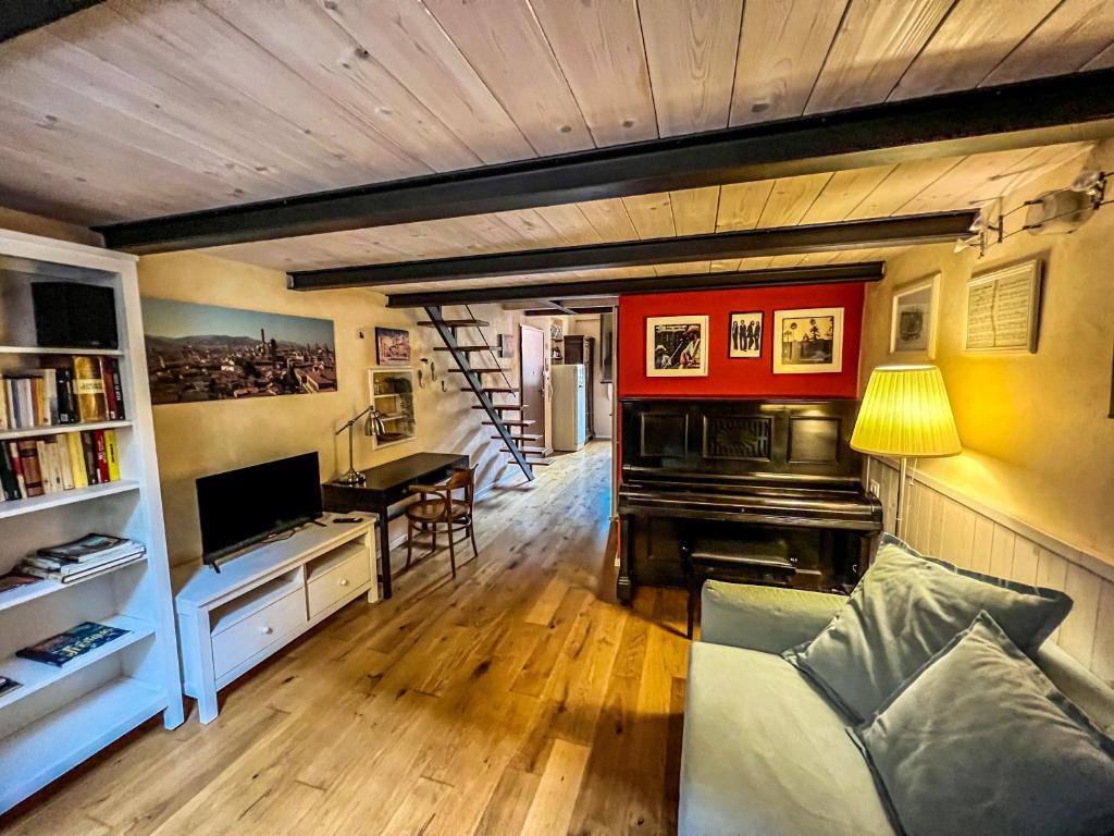 un soggiorno con pianoforte e scala di Without Name Apartment a Bologna
