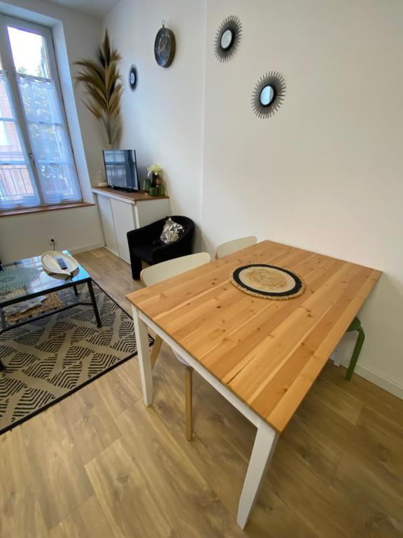 a wooden table in a living room with a table at Le Studio in Montauban