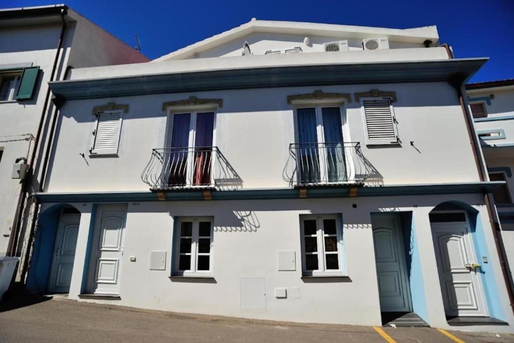 - un bâtiment blanc avec un balcon dans une rue dans l'établissement CasaFrancesca Calasetta, à Calasetta