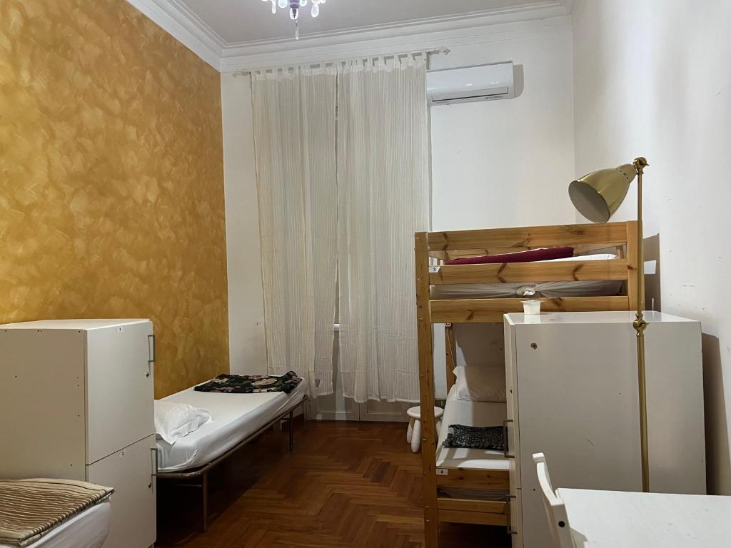 a small room with a bed and a bunk bed and a ladder at Varese Guest House in Rome