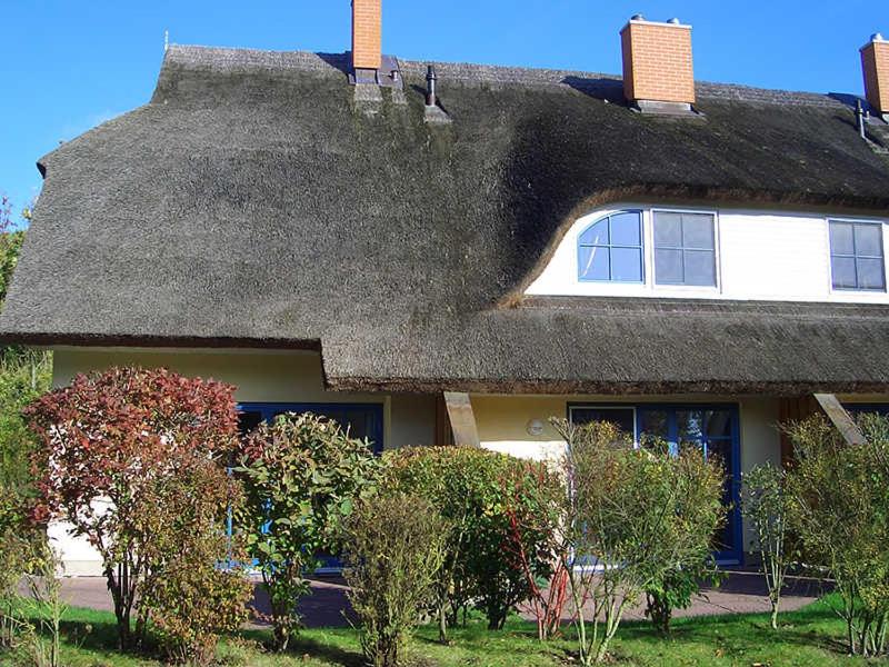 ein strohgedecktes Haus mit einem Strohdach in der Unterkunft Reetdachhaus Malve 3 im Feriendorf Puddeminer Wiek in Puddemin