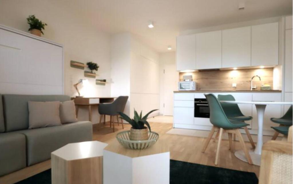 eine Küche und ein Wohnzimmer mit einem Sofa und einem Tisch in der Unterkunft Central fully serviced studio in Luxemburg (Stadt)
