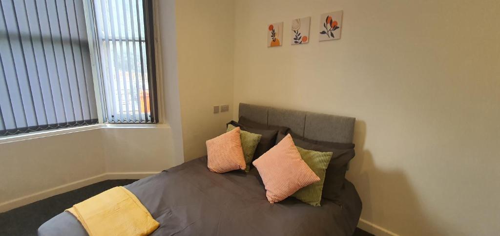 a bedroom with a bed with pillows on it at Leicester City Apartments in Leicester