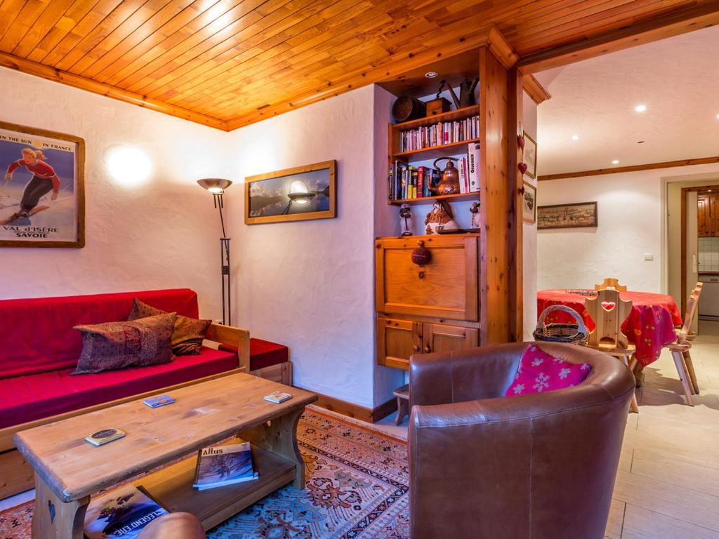 un salon avec un canapé rouge et une table dans l'établissement Appartement spacieux pour 6, proche pistes et centre aquasportif à Val-d'Isère - FR-1-694-194, à Val dʼIsère