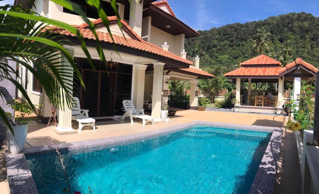 a swimming pool in front of a house at Orchid Pool -Villa 3 bedrooms in Ko Lanta