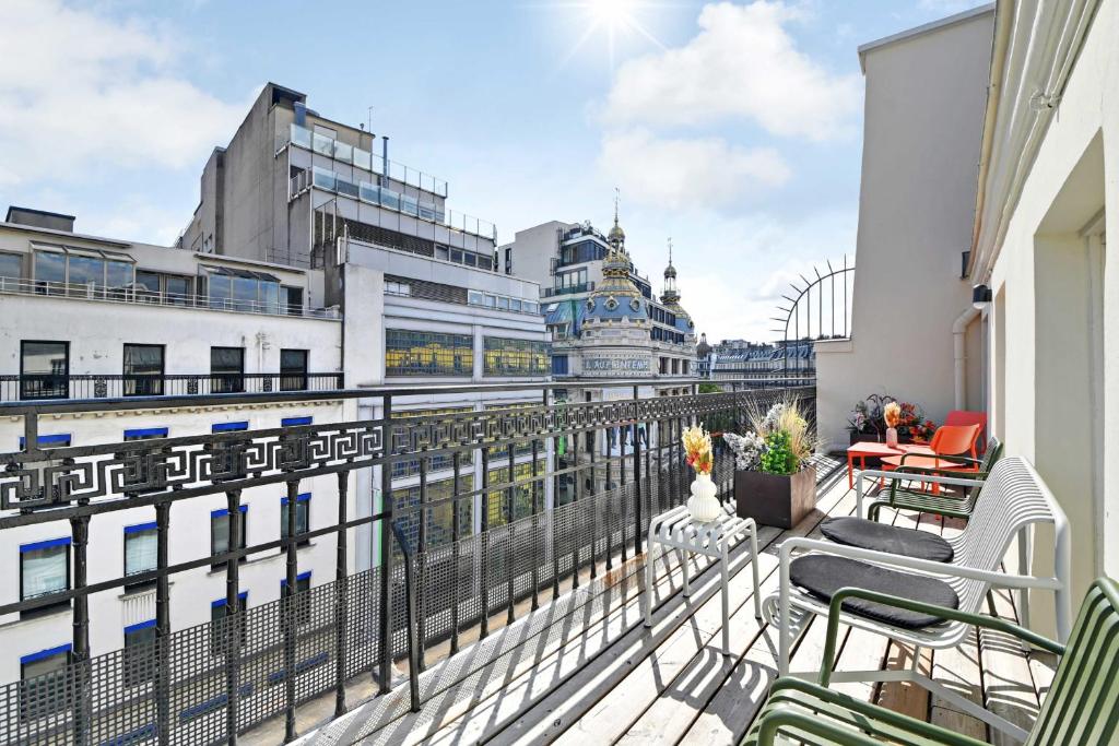 un balcon avec des chaises et des tables sur un immeuble dans l'établissement Exceptional apartment - 4BR-10P - Opéra, à Paris