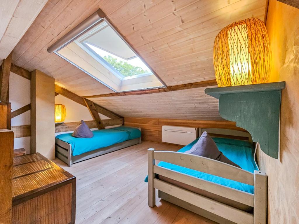 a room with two beds and a window at Gîte Au Jardin in Meilhan-sur-Garonne