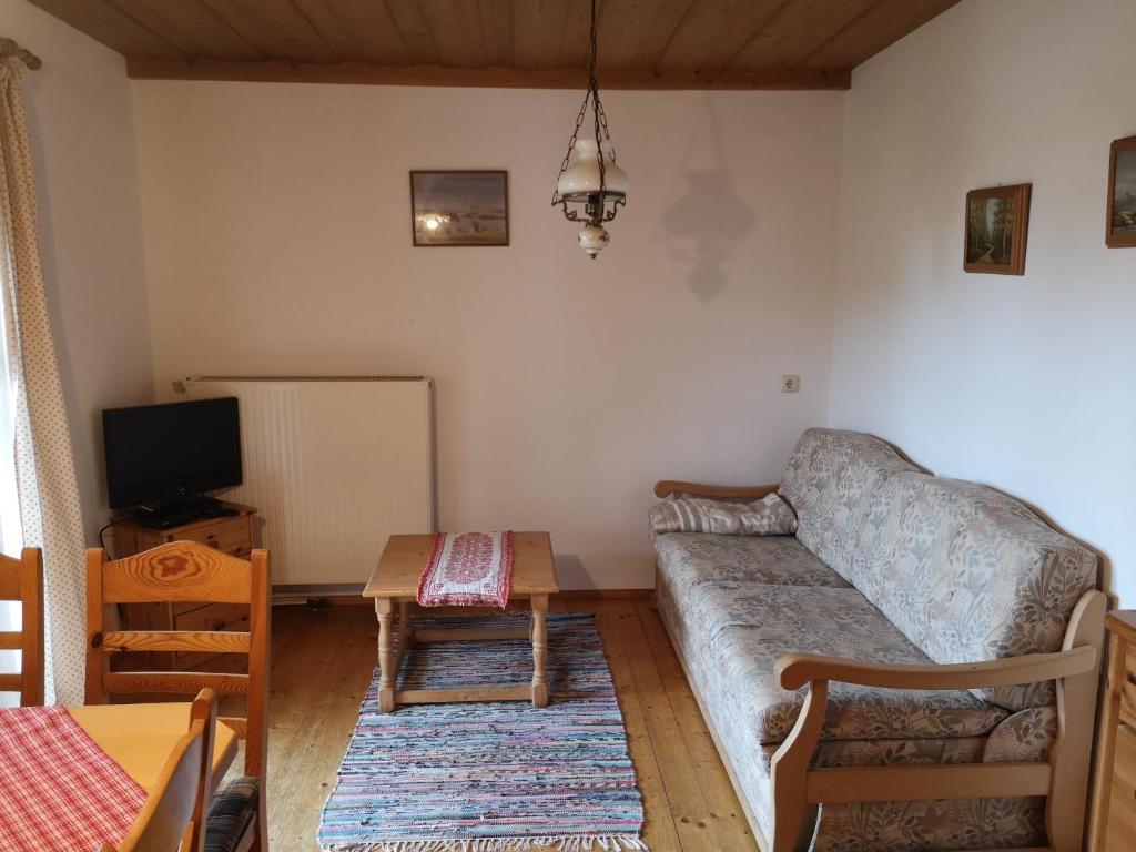 a living room with a couch and a table at Ferienwohnung Niklas in Saulgrub