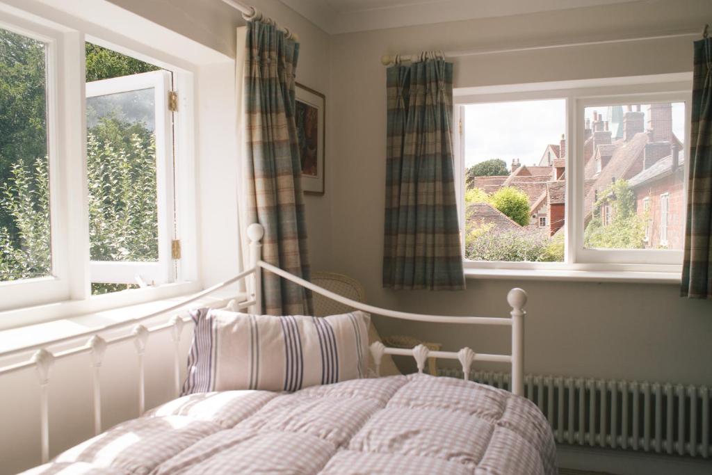 een slaapkamer met een bed en 2 ramen bij Blossom Barn Harting in South Harting