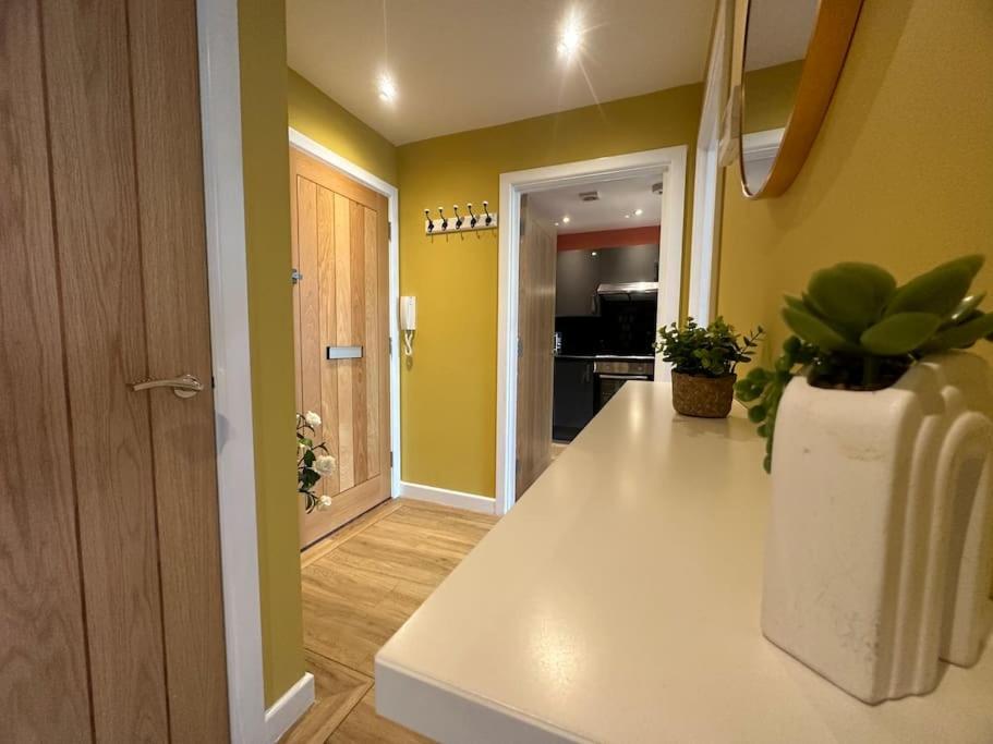 a kitchen with yellow walls and a white counter top at Open Mind Property - Luxury Apartment in the City in Portsmouth