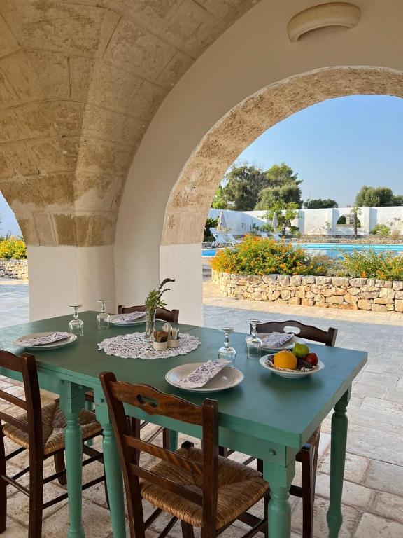 a table with plates of food on it under an archway at Masseria Gorgognolo in Ostuni