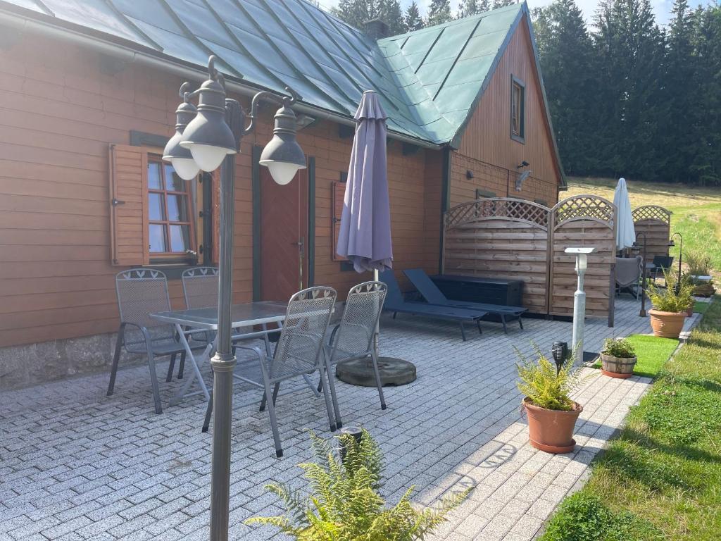 a patio with a table and chairs and an umbrella at Chybotek. Domek in Przesieka