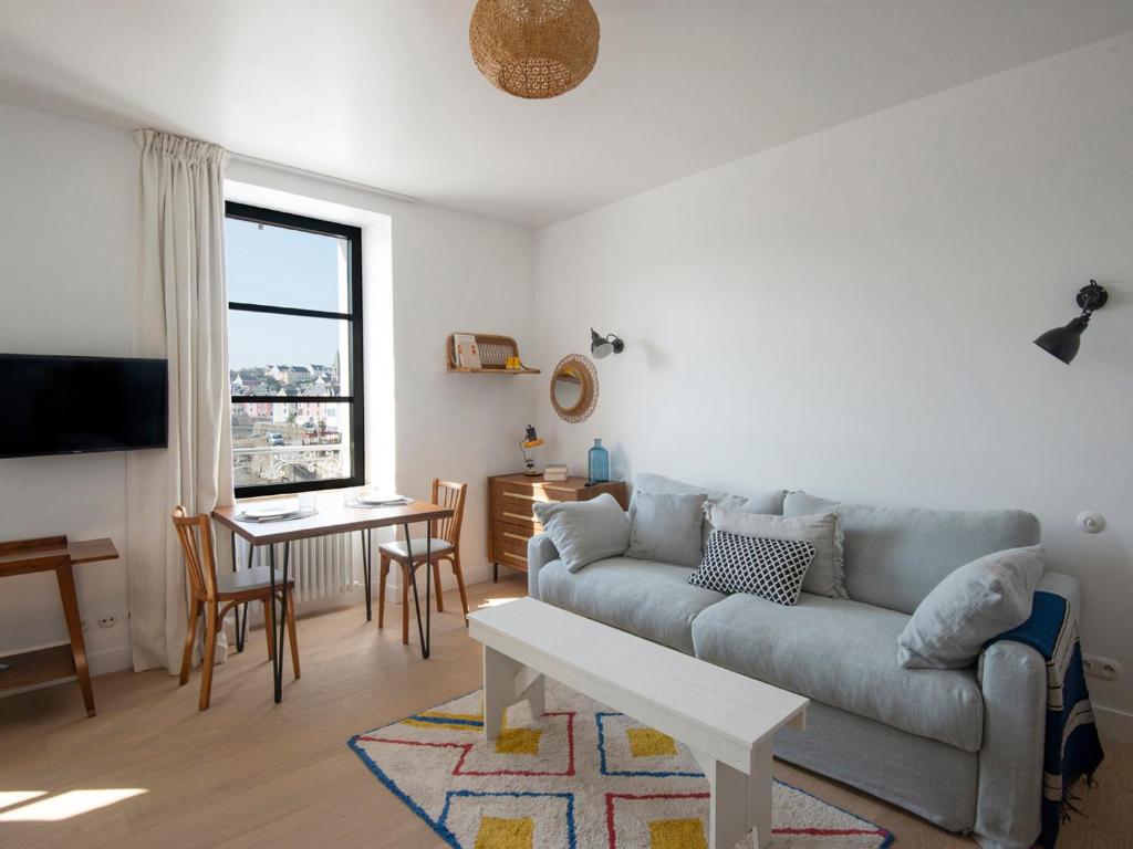 een woonkamer met een bank en een tafel bij Studio Sauzon, 1 pièce, 2 personnes - FR-1-418-227 in Sauzon