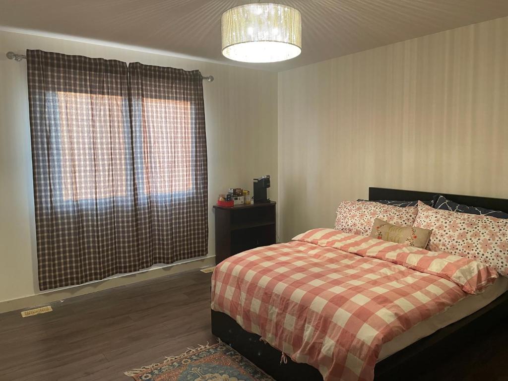 1 dormitorio con 1 cama con manta a cuadros en Winter Madness Vibes, en Sylvan Lake