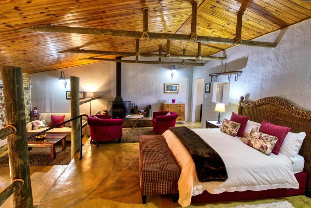 a bedroom with a large bed and a living room at Wetlands Country House & Sheds in Wakkerstroom