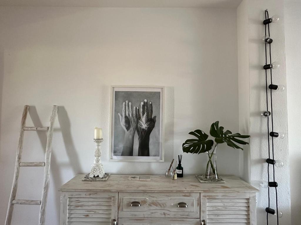 Habitación blanca con tocador con una foto en la pared en Charming & cosy beach apartment, en Torremolinos