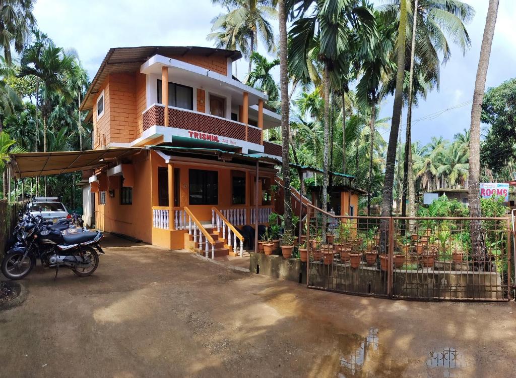 a house with a motorcycle parked in front of it at Trishula Farm House in Gokarna