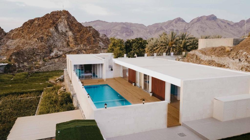 a house on a hill with a swimming pool at Jeema lodge in Hatta
