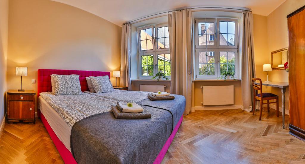 a bedroom with a large bed with two towels on it at Apartament Bursztynowy Mariacka Old Town in Gdańsk