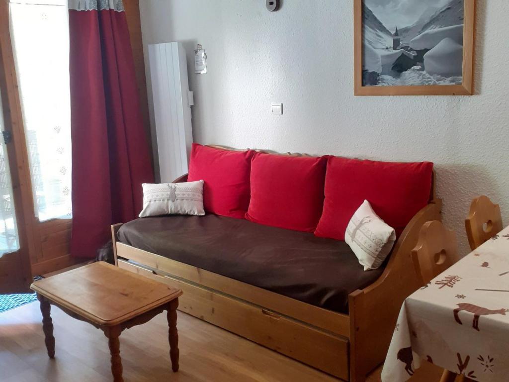 - un canapé avec des oreillers rouges dans le salon dans l'établissement Appartement Valloire, 2 pièces, 4 personnes - FR-1-263-400, à Valloire