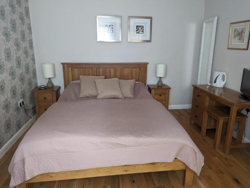 a bedroom with a large bed and two night stands at The Willoughby in Little Bytham