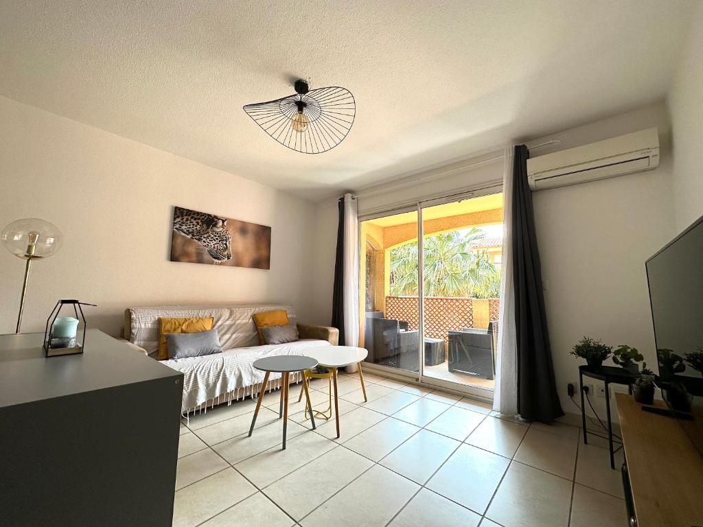 a living room with a couch and a table at Malibu Village T2 in Canet-en-Roussillon