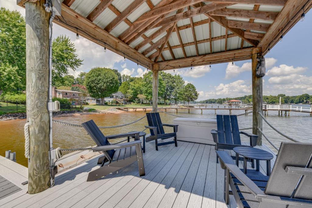 um deque de madeira com cadeiras azuis na água em Pet-Friendly Lake Norman Home with Boat Dock! em Mooresville