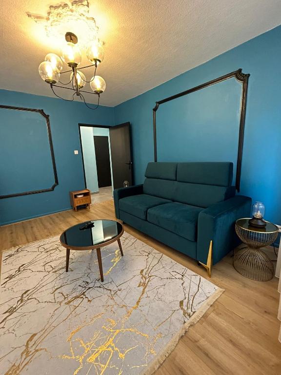 een woonkamer met een blauwe bank en een tafel bij Petite France Apartment Strasbourg in Straatsburg