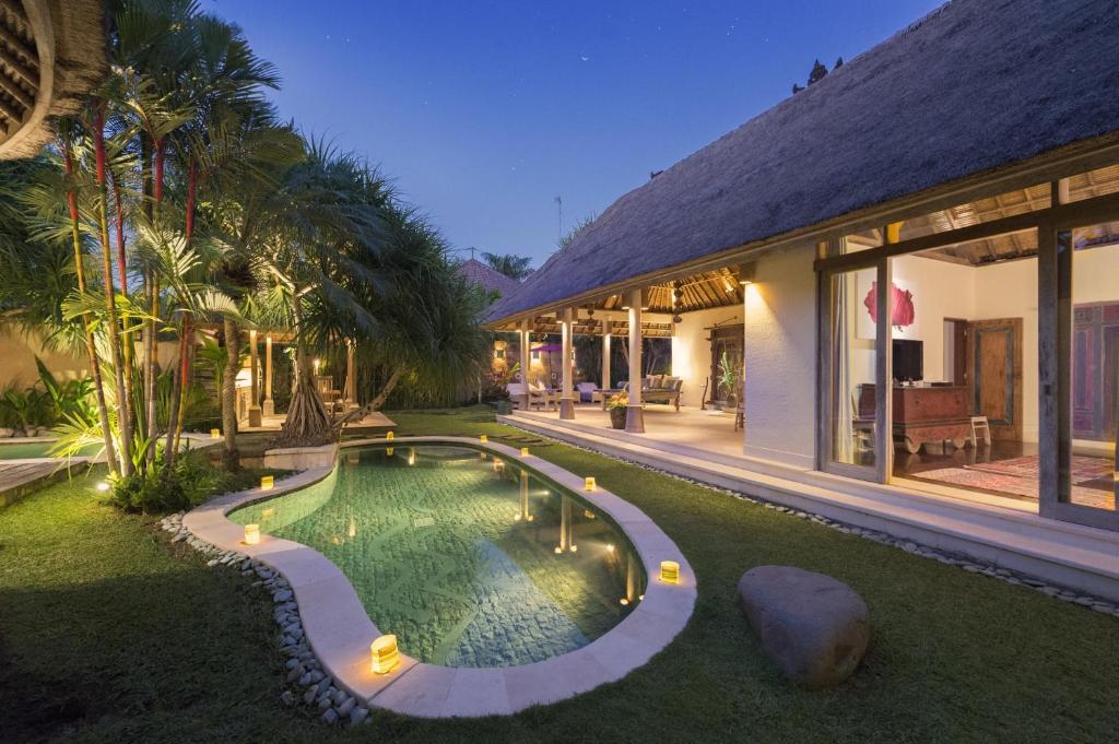 een huis met een zwembad in de tuin bij Villa Tirta Naga Bali in Seminyak