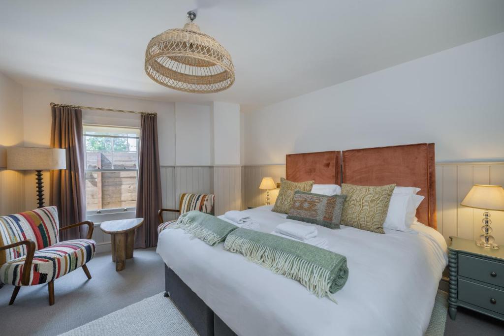 a bedroom with a large bed and a chair at The Railway Hotel Worthing in Worthing