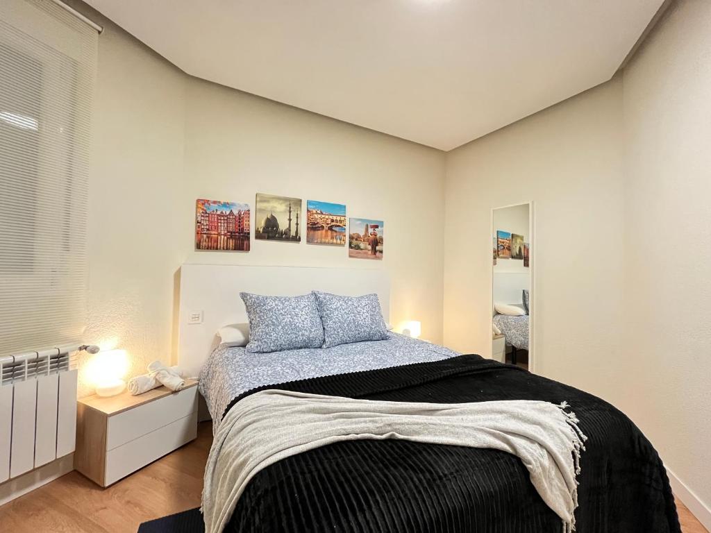Un dormitorio con una cama con almohadas azules. en Acogedor Atocha Ile Sebastian, en Madrid