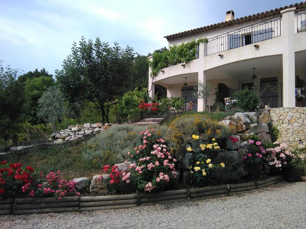 a garden in front of a house with flowers at Mas des Grives in Bauduen