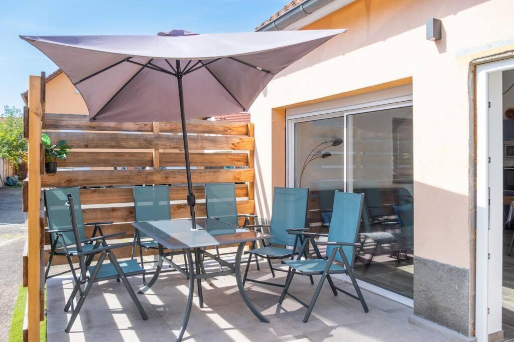 a table and chairs under an umbrella on a patio at Nouveau - Le Privacy - Europa Park in Sand