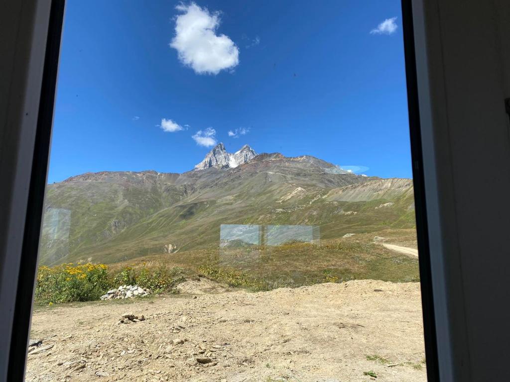 Blick auf einen Berg von einem Zugfenster aus in der Unterkunft სასტუმრო ქორულდი / Hotel Koruldi in Mestia